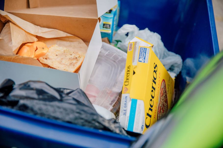 A Recycling Bin with recyclable materials, cans and paper
